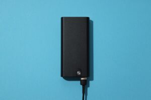 Powerbank with cord on blue background, top view