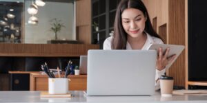 Young asian businesswoman works on tablet with laptop at the office.